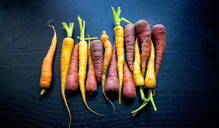 Photo of carrots against black background.