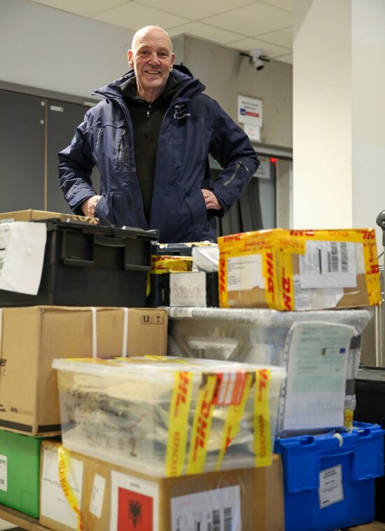man standing behind packed boxes