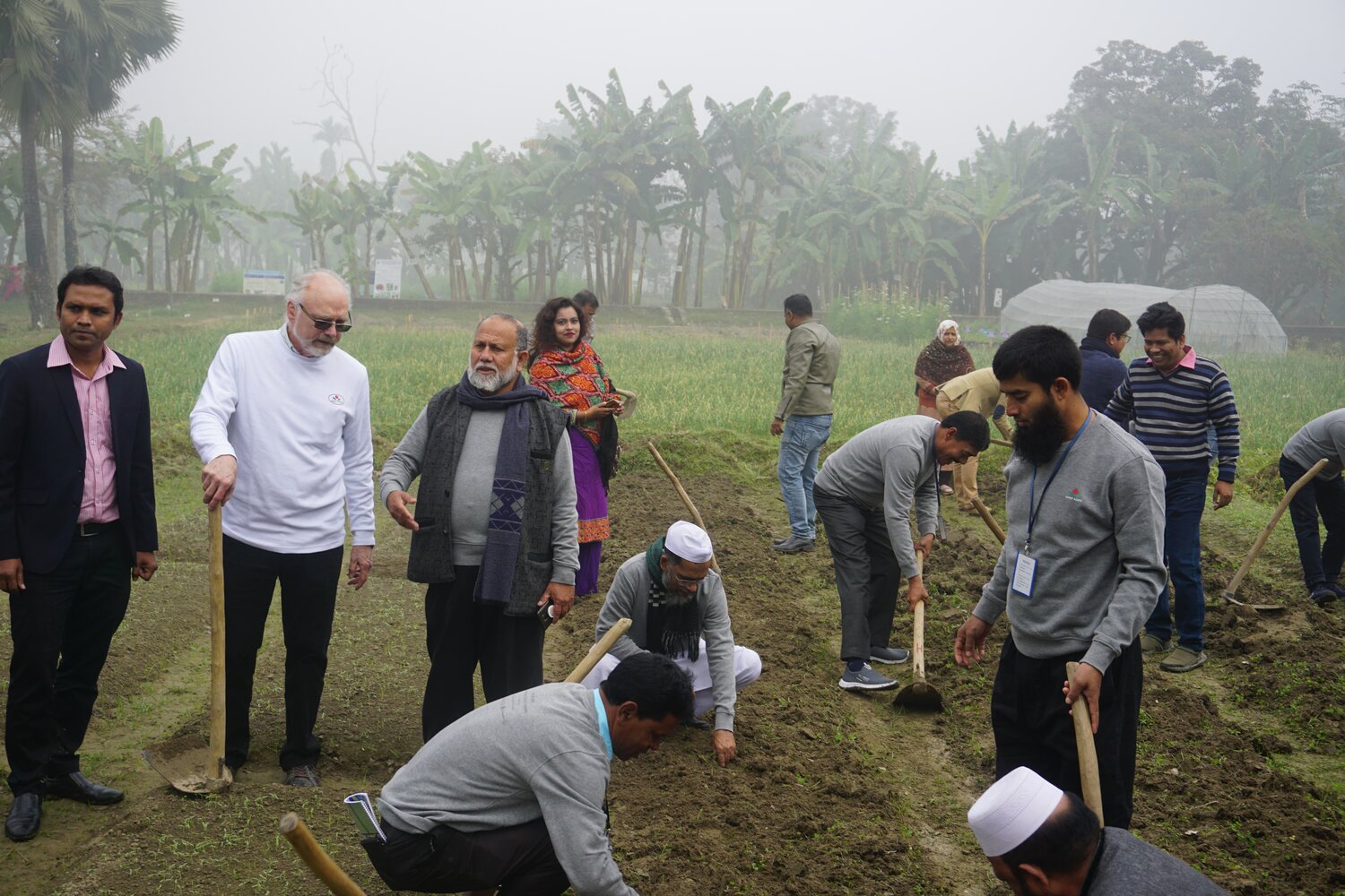 Phil Simon (in white), from the United States Department of Agriculture (USDA), leader of the international carrot pre-breeding project, in discussion with Rahim, while carrot seed production trainers learn how to sow the crop. 
